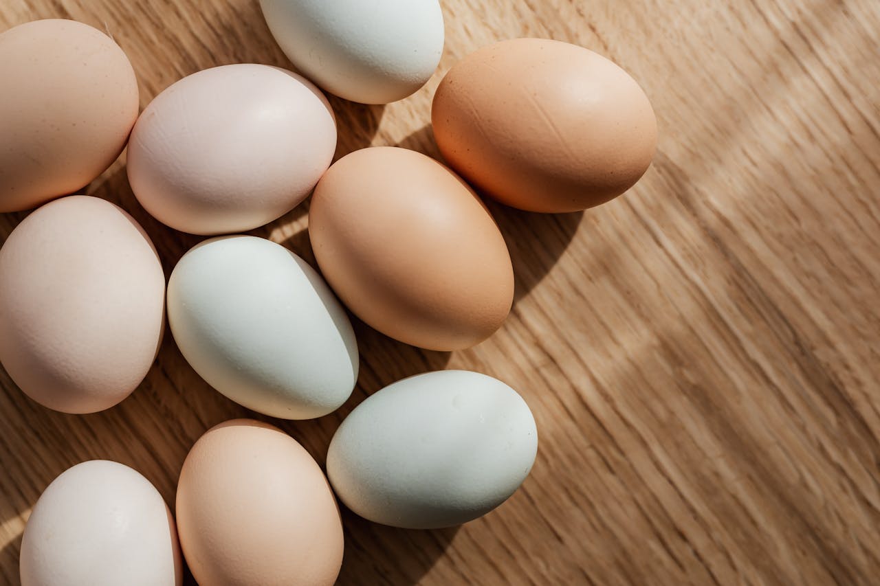 hero-gallery-02 Top view of assorted mixed chicken raw multicolored eggs placed together on wooden surface during daytime