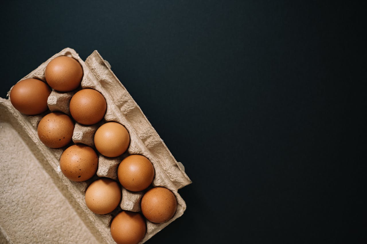 A close-up of organic brown eggs neatly arranged in a sustainable, eco-friendly egg carton. Perfect for Easter or cooking inspiration.